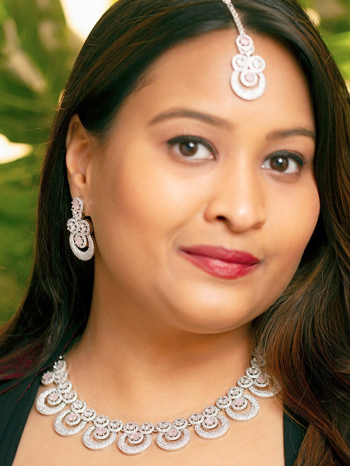 A woman showcasing a beautiful artificial diamond necklace with mint pink colored stone and earrings set and maangtikka, ideal for festivals, family gatherings, and special celebrations in India. This elegant diamond jewelry provides the perfect blend of sparkle and tradition, with a modern twist.