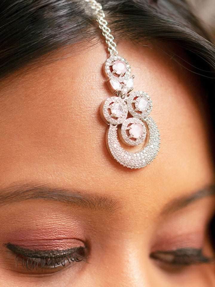 Close-up of a woman wearing a sparkling artificial diamond necklace with mint pink colored stone and diamond earrings maangtikka set, designed to offer a radiant, elegant look for any formal occasion or Indian wedding. This affordable diamond jewelry provides a flawless, luxurious alternative to natural diamonds.