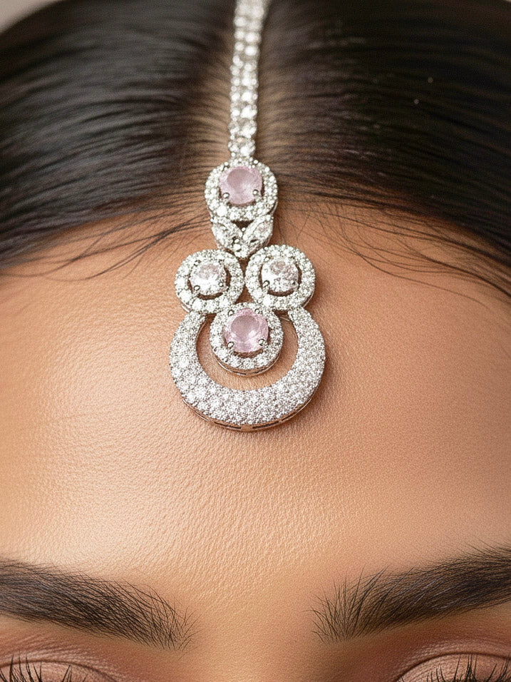 Close-up of a woman wearing an ornate Western Mint Pink Diamond SIlver Collar jewellery set and earrings and maangtikka with American Diamond and Mint Pink Colored Stones. Bride-to-be styled in a premium American diamond artificial necklace for her reception party. Close-up of a bridal look featuring an anti-tarnish American diamond artificial necklace.