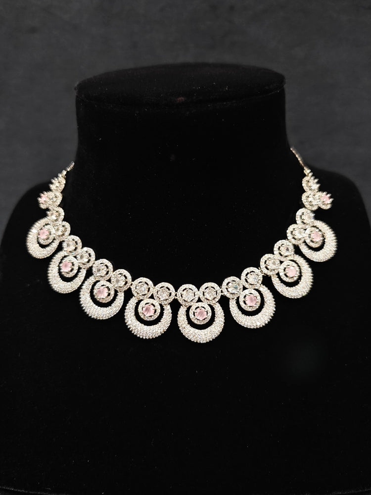 Close-up of an ornate Western Mint Pink Diamond SIlver Collar jewellery set and earrings and maangtikka with American Diamond and Mint Pink Colored Stones. A premium American diamond artificial necklace for her reception party. Close-up of a bridal look featuring an anti-tarnish American diamond artificial necklace.