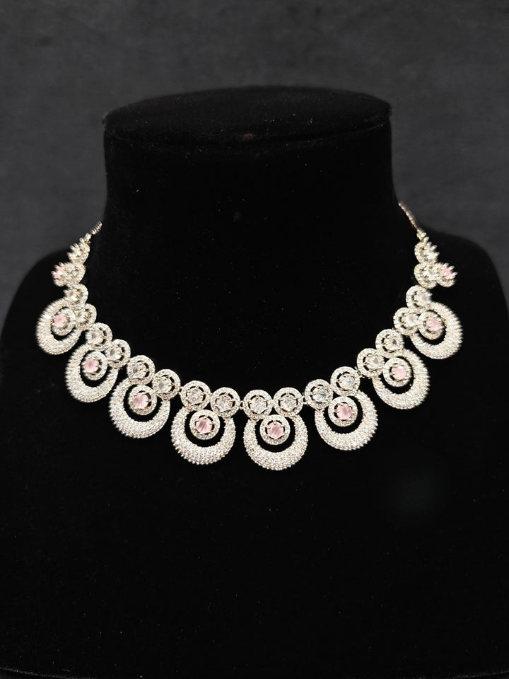 Close-up of an ornate Western Mint Pink Diamond SIlver Collar jewellery set and earrings and maangtikka with American Diamond and Mint Pink Colored Stones. A premium American diamond artificial necklace for her reception party. Close-up of a bridal look featuring an anti-tarnish American diamond artificial necklace.