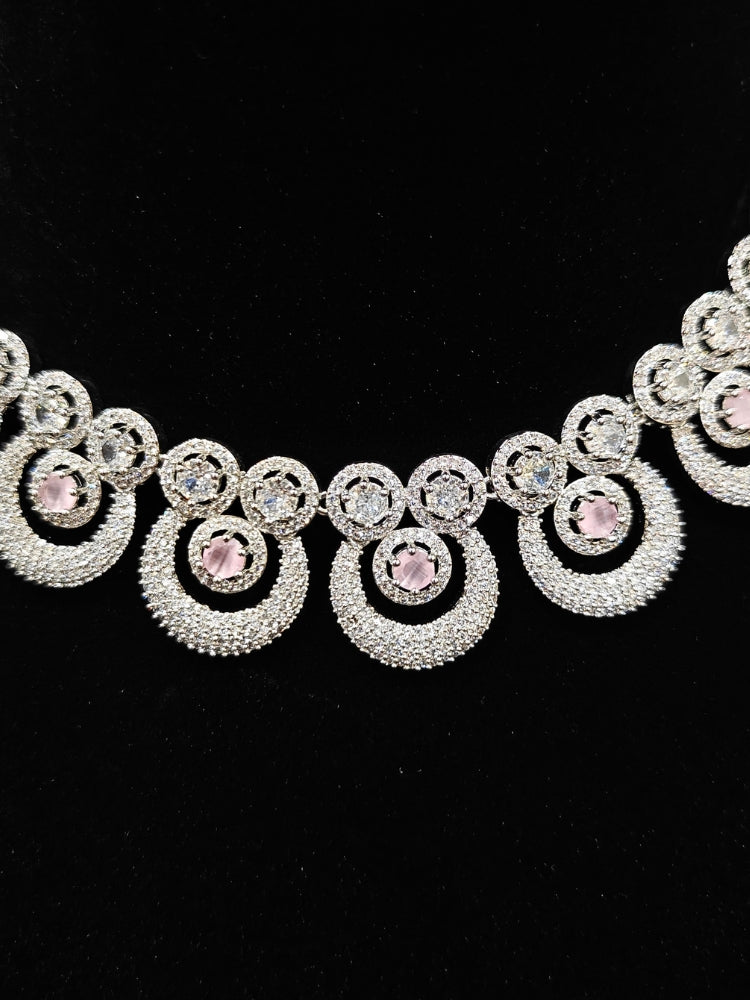 Close-up of an ornate Western Mint Pink Diamond SIlver Collar jewellery set and earrings and maangtikka with American Diamond and Mint Pink Colored Stones. A premium American diamond artificial necklace for her reception party. Close-up of a bridal look featuring an anti-tarnish American diamond artificial necklace.