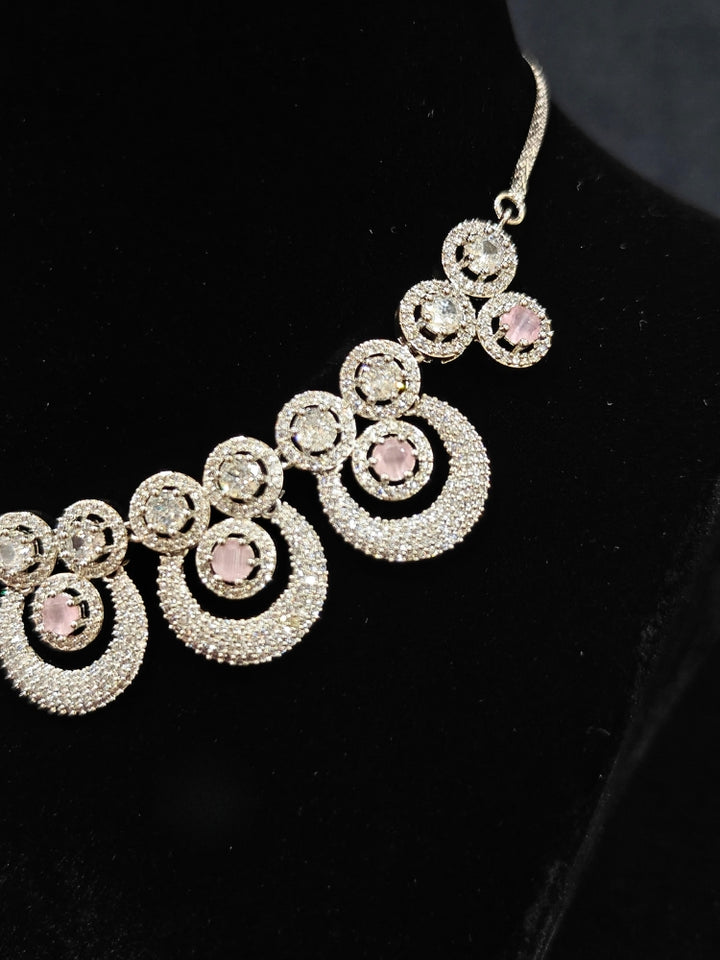 Close-up of an ornate Western Mint Pink Diamond SIlver Collar jewellery set and earrings and maangtikka with American Diamond and Mint Pink Colored Stones. A premium American diamond artificial necklace for her reception party. Close-up of a bridal look featuring an anti-tarnish American diamond artificial necklace.