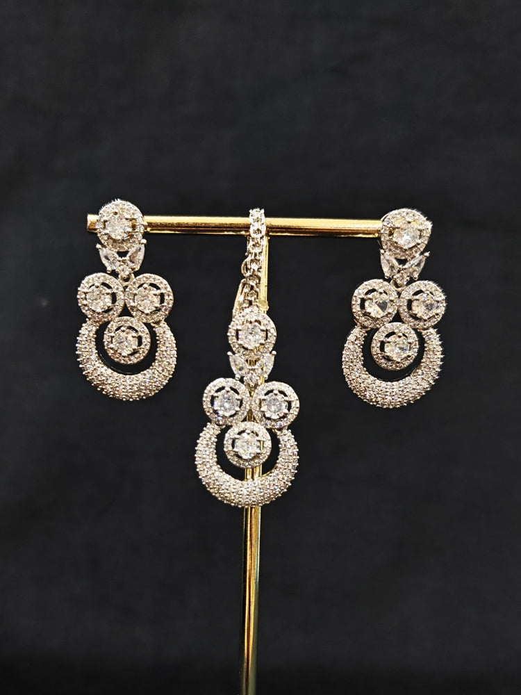 Close-up of an ornate Western Diamond SIlver Collar jewellery set and earrings and maangtikka with American Diamond. A premium American diamond artificial necklace for her reception party. Close-up of a bridal look featuring an anti-tarnish American diamond artificial necklace.