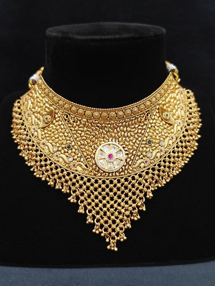 Close-up of an ornate traditional (gold Polish) Choker jewellery set and earrings and maangtikka with Polki, Pink Colored Stone. A luxury artificial jewelry set styled for an Indian wedding celebration. Bride showcasing a premium imitation jewelry set for her reception look.