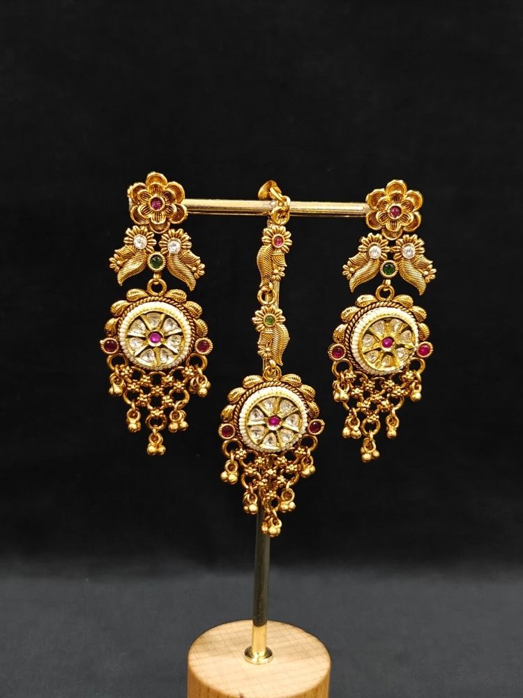 Close-up of an ornate traditional (gold Polish) Choker jewellery set and earrings and maangtikka with Polki, Pink Colored Stone. A luxury artificial jewelry set styled for an Indian wedding celebration. Bride showcasing a premium imitation jewelry set for her reception look.