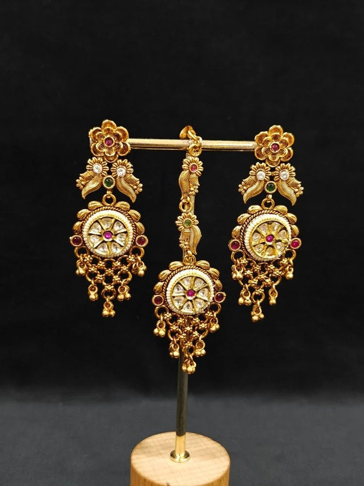 Close-up of an ornate traditional (gold Polish) Choker jewellery set and earrings and maangtikka with Polki, Pink Colored Stone. A luxury artificial jewelry set styled for an Indian wedding celebration. Bride showcasing a premium imitation jewelry set for her reception look.