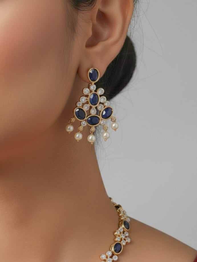 Close-up of a woman wearing an ornate traditional Blue (gold Polish) Collar jewellery set and earrings with Colored Stones and American Diamonds. Festive Diwali outfit styled with an Colored Stone artificial necklace.