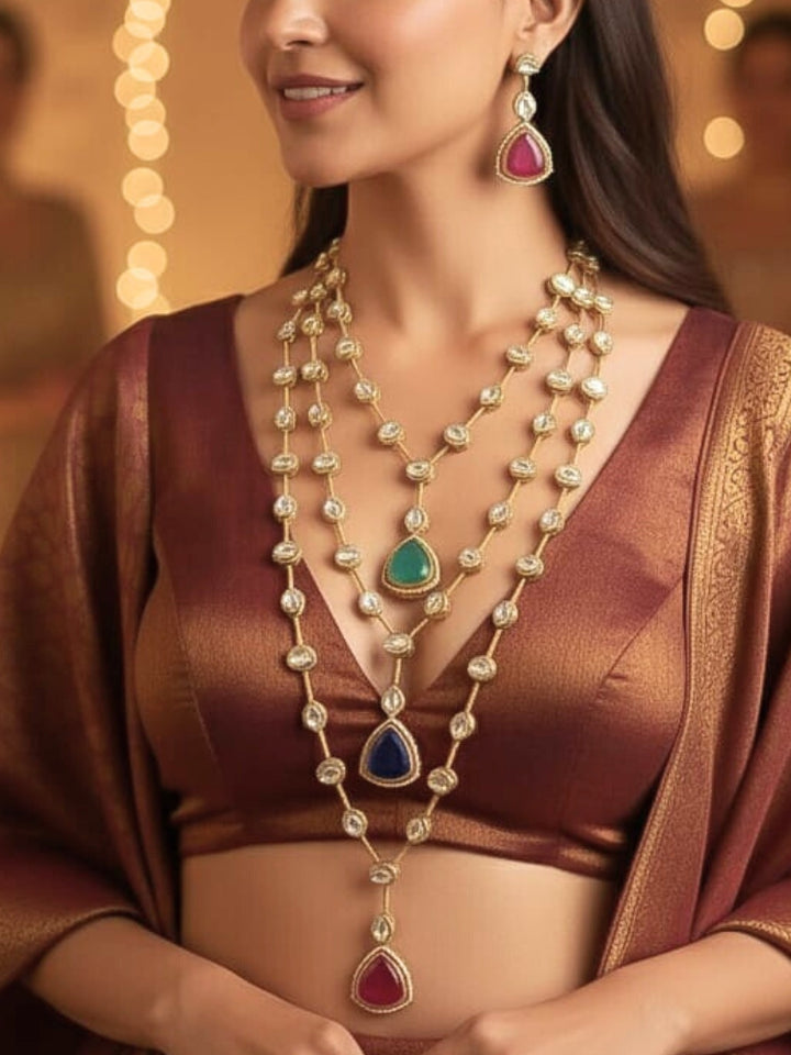 Close-up of a woman wearing an ornate Indo-western (Gold Polish) Multi-Color Long Layered Necklace set with Kundan and Colored Stones. Indo-western outfit styled with a Kundan necklace. Wedding celebration look enhanced with a statement Kundan necklace.