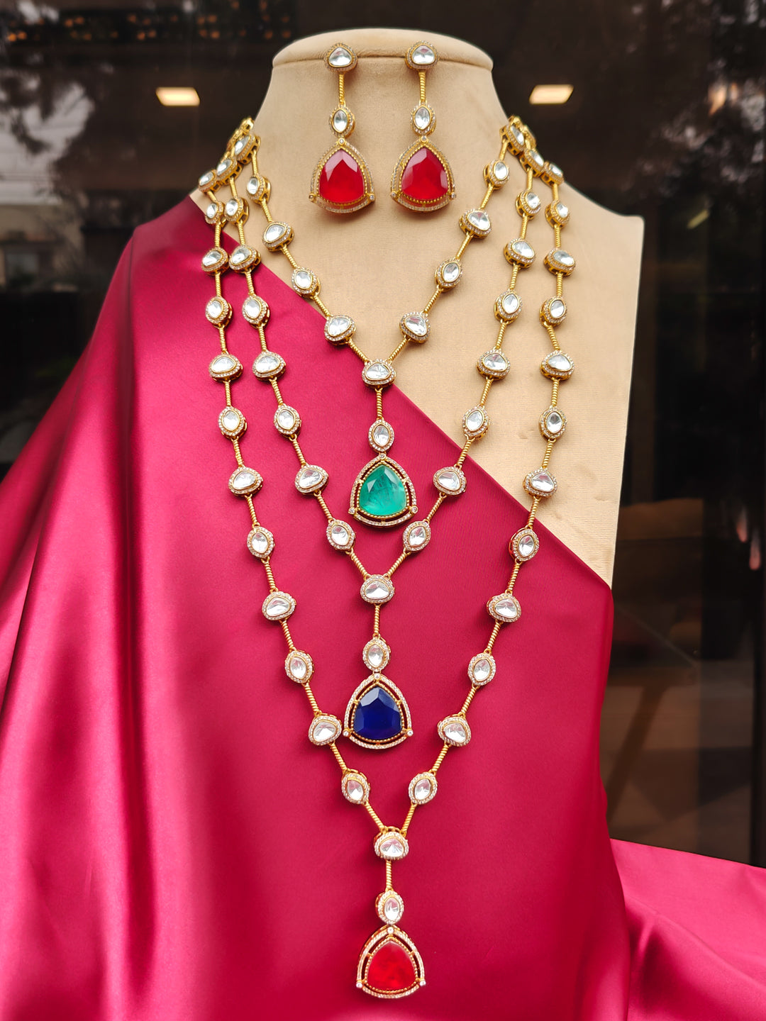 Close-up of an ornate Indo-western (Gold Polish) Multi-Color Long Layered Necklace set with Kundan and Colored Stones. Indo-western outfit styled with a Kundan necklace. Wedding celebration look enhanced with a statement Kundan necklace.