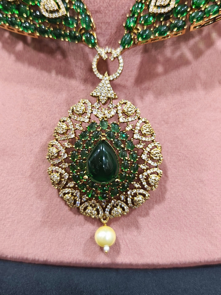 A luxurious artificial diamond jewelry featuring a designer diamond necklace, pota stone and green colored stone and earrings set, crafted for bridal fashion and high-end weddings. This beautiful diamond jewelry set offers the brilliance of real diamonds at an affordable price.