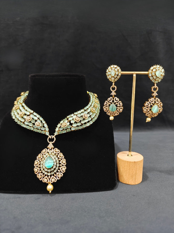 A sparkling artificial diamond, pota stone and mint green colored stone necklace and diamond earrings set, designed to offer a radiant, elegant look for any formal occasion or Indian wedding. This affordable diamond jewelry provides a flawless, luxurious alternative to natural diamonds.