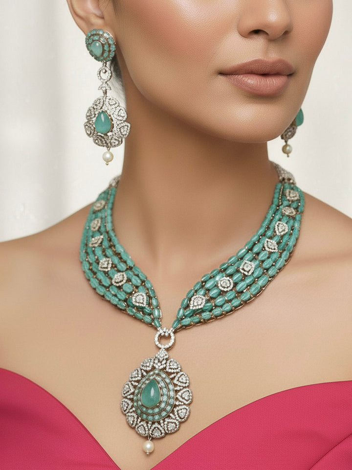 "Close-up of a woman wearing a sparkling artificial diamond, pota stone and mint green colored stone necklace and diamond earrings set, designed to offer a radiant, elegant look for any formal occasion or Indian wedding. This affordable diamond jewelry provides a flawless, luxurious alternative to natural diamonds."
