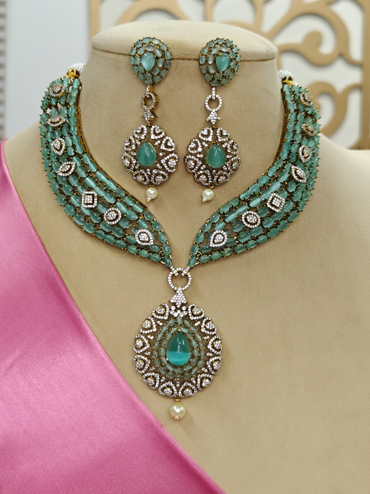 "A beautiful woman wearing an elegant artificial diamond, pota stone and mint green colored stone necklace and matching earrings. This premium artificial diamond jewelry set is perfect for special occasions, from Indian weddings to engagement parties, offering sophisticated glamour without the high price tag."
