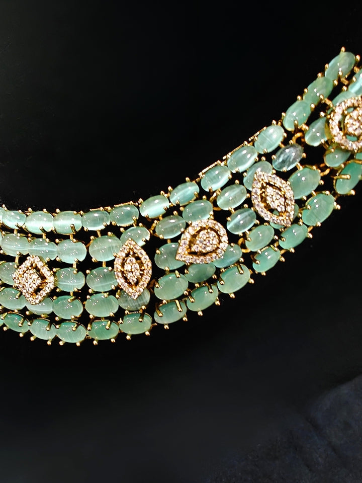 A sparkling artificial diamond, pota stone and mint green colored stone necklace and diamond earrings set, designed to offer a radiant, elegant look for any formal occasion or Indian wedding. This affordable diamond jewelry provides a flawless, luxurious alternative to natural diamonds.