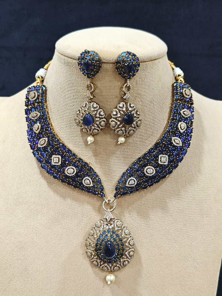 An exquisite artificial diamond, pota stone and navy blue colored stone necklace and matching earrings, designed for the perfect engagement look. This stunning artificial diamond jewelry set offers luxury and sophistication while being an affordable alternative to natural diamonds.