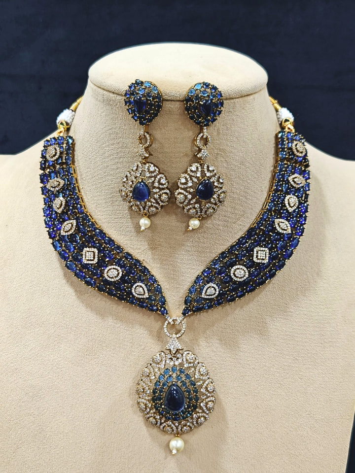 An exquisite artificial diamond, pota stone and navy blue colored stone necklace and matching earrings, designed for the perfect engagement look. This stunning artificial diamond jewelry set offers luxury and sophistication while being an affordable alternative to natural diamonds.