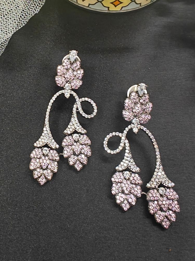 Introducing Grapevile Earrings: ornate American Diamond grapevine shaped earrings featuring pink gemstones along with american diamonds in leaf-like clusters, displayed against a black background.