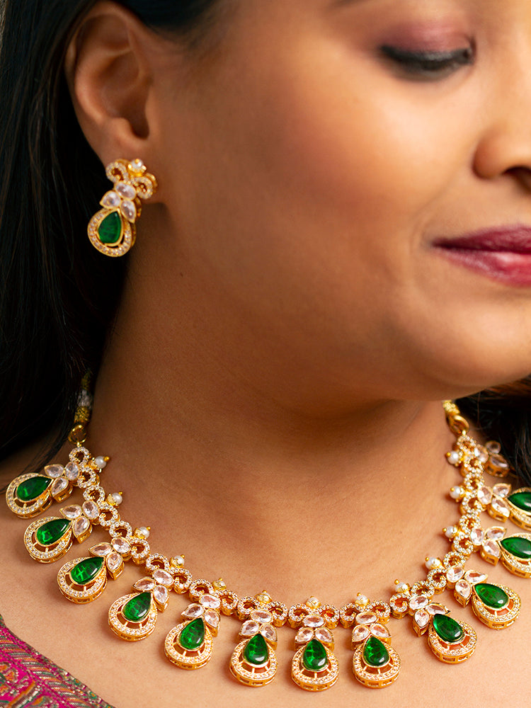 Close-up of a model in luxurious artificial diamond jewelry featuring a designer diamond necklace with green colored stone and earrings set, crafted for bridal fashion and high-end weddings. This beautiful diamond jewelry set offers the brilliance of real diamonds at an affordable price.