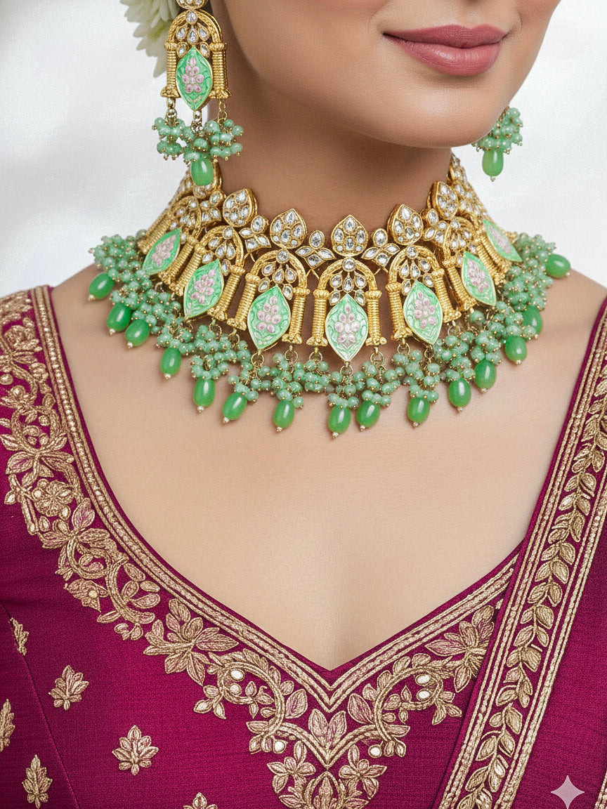 Close-up of a woman wearing an ornate traditional (Gold Polish) Green Choker jewellery set and earrings and maangtikka with Kundan, Meenakari, Crystal beads and Tumble beads. Close-up of intricate Kundan craftsmanship in artificial bridal jewelry. Bride wearing a traditional Kundan artificial necklace set for her wedding ceremony.