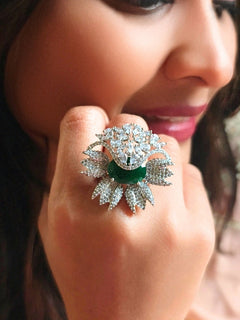 Close-up of a woman wearing an ornate Western (Silver Polish) Green Ring with American Diamond and Green Colored Stones. Party wear outfit completed with a lightweight American diamond Ring. Elegant wedding jewelry look featuring a premium artificial American diamond Ring.