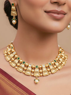 Close-up of a woman wearing an ornate traditional Green Rajwadi gold Collar jewellery set and earrings  with  Colored Stone and Kundan. Festive Diwali outfit enhanced with a Rajwadi artificial necklace. Close-up of a premium Rajwadi artificial necklace under 10000.