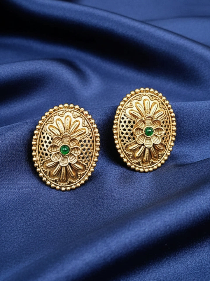 Close-up of an ornate traditional (Gold Polish) Studs Earrings with Filigree Work and Colored Stone. Festive Diwali outfit paired with a colorful Colored Stone Earrings. Festive celebration look enhanced with traditional Colored Stone Earrings.