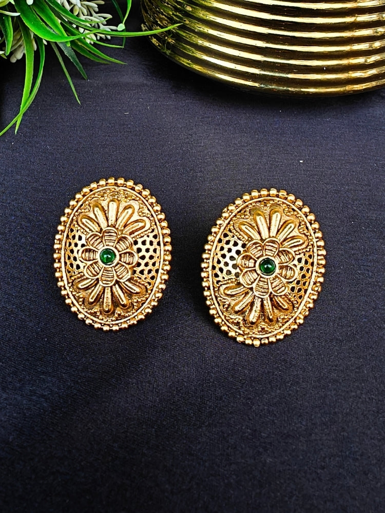 Close-up of an ornate traditional (Gold Polish) Studs Earrings with Filigree Work and Colored Stone. Festive Diwali outfit paired with a colorful Colored Stone Earrings. Festive celebration look enhanced with traditional Colored Stone Earrings.