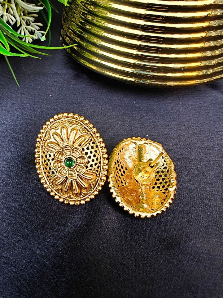 Close-up of an ornate traditional (Gold Polish) Studs Earrings with Filigree Work and Colored Stone. Festive Diwali outfit paired with a colorful Colored Stone Earrings. Festive celebration look enhanced with traditional Colored Stone Earrings.