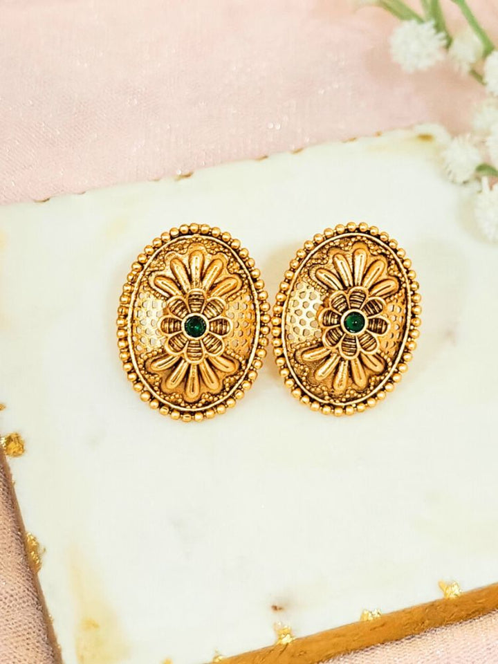 Close-up of an ornate traditional (Gold Polish) Studs Earrings with Filigree Work and Colored Stone. Festive Diwali outfit paired with a colorful Colored Stone Earrings. Festive celebration look enhanced with traditional Colored Stone Earrings.