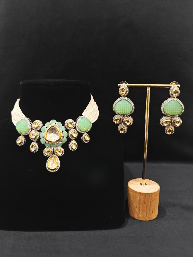 Close-up of an ornate traditional Green Collar Kundan jewellery set and earrings with American diamonds, Monalisa stone, Pearls, Kundan and Colored Stones. Festive Diwali outfit paired with a premium Kundan jewelry piece. A trending Kundan artificial jewelry for wedding season in India.