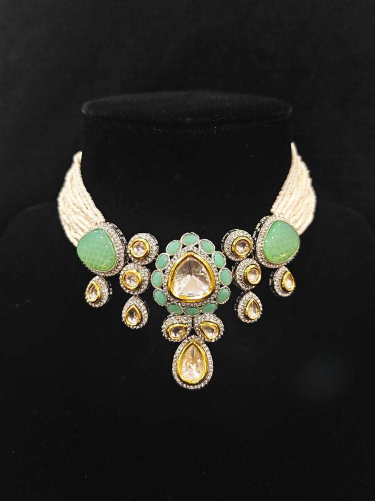 Close-up of an ornate traditional Green Collar Kundan jewellery set and earrings with American diamonds, Monalisa stone, Pearls, Kundan and Colored Stones. Festive Diwali outfit paired with a premium Kundan jewelry piece. A trending Kundan artificial jewelry for wedding season in India.