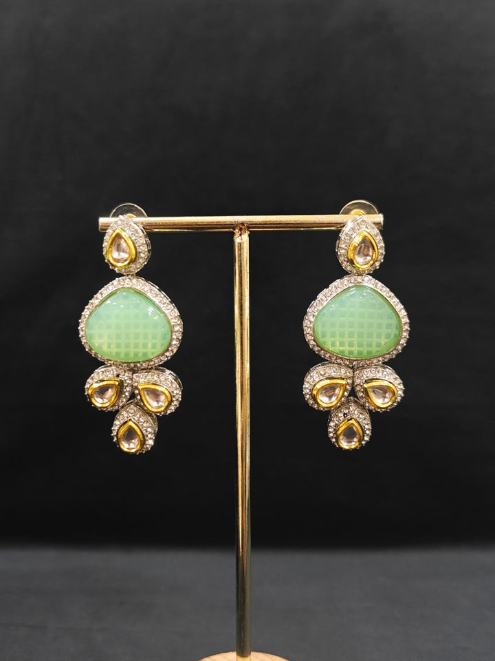 Close-up of an ornate traditional Green Collar Kundan jewellery set and earrings with American diamonds, Monalisa stone, Pearls, Kundan and Colored Stones. Festive Diwali outfit paired with a premium Kundan jewelry piece. A trending Kundan artificial jewelry for wedding season in India.