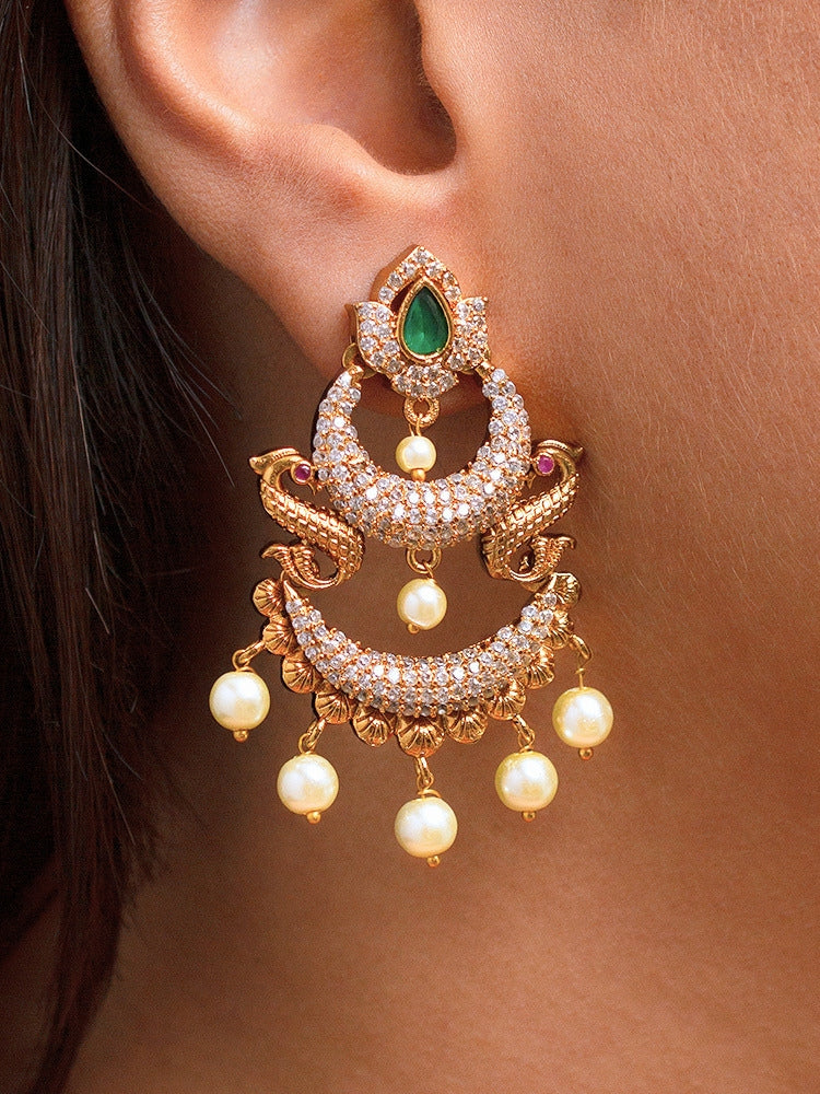 Close-up of a woman wearing an ornate traditional (gold Polish) Green Diamond  Earrings with American Diamond and Pearls. A woman wearing a luxury American diamond Earrings styled beautifully for a wedding guest look in India. Festive Diwali outfit styled with an American diamond artificial Earrings.