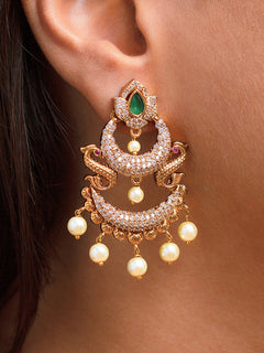 Close-up of a woman wearing an ornate traditional (gold Polish) Green Diamond  Earrings with American Diamond and Pearls. A woman wearing a luxury American diamond Earrings styled beautifully for a wedding guest look in India. Festive Diwali outfit styled with an American diamond artificial Earrings.