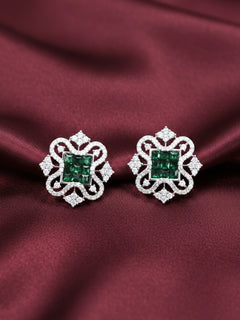 Close-up of an ornate Western (Silver Polish) Dark Green Diamond Studs Earrings with American Diamond. western dress styled with lightweight artificial American Diamond studs earrings. Wear in office and everyday.
