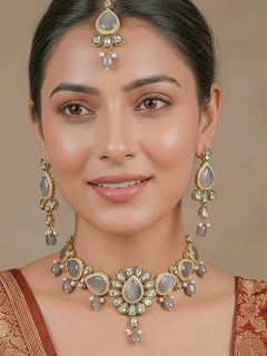 Close-up of a woman wearing an ornate traditional Grey Choker jewellery set and earrings and maangtikka with Kundan, Monalisa Stone, American Diamonds, Beads and Reverse American Diamonds and tumble stones. A graceful woman wearing a trending Colored Stone necklace for a 2026 wedding celebration. Elegant wedding jewelry look featuring a premium artificial Colored Stone necklace.
