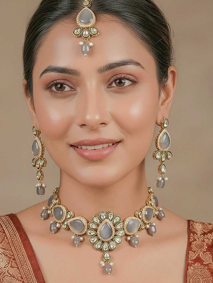 Close-up of a woman wearing an ornate traditional Grey Choker jewellery set and earrings and maangtikka with Kundan, Monalisa Stone, American Diamonds, Beads and Reverse American Diamonds and tumble stones. A graceful woman wearing a trending Colored Stone necklace for a 2026 wedding celebration. Elegant wedding jewelry look featuring a premium artificial Colored Stone necklace.