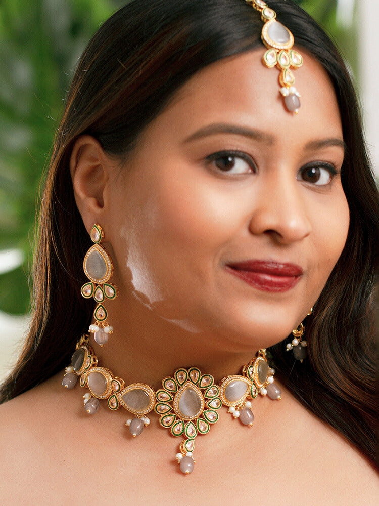 Close-up of a woman wearing an ornate traditional Grey Choker jewellery set and earrings and maangtikka with Kundan, Monalisa Stone, American Diamonds, Beads and Reverse American Diamonds and tumble stones. A graceful woman wearing a trending Colored Stone necklace for a 2026 wedding celebration. Elegant wedding jewelry look featuring a premium artificial Colored Stone necklace.
