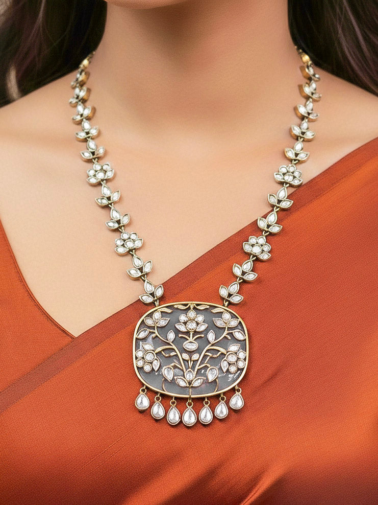 Close-up of a woman wearing an ornate traditional Grey Kundan jewellery set and earrings with Kundan and Colored Stones. Saree look completed with a traditional artificial Kundan set. Woman wearing trending Kundan artificial jewelry for wedding season in India.