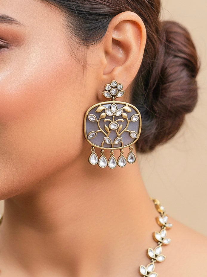 Close-up of a woman wearing an ornate traditional Grey Kundan jewellery set and earrings with Kundan and Colored Stones. Saree look completed with a traditional artificial Kundan set. Woman wearing trending Kundan artificial jewelry for wedding season in India.
