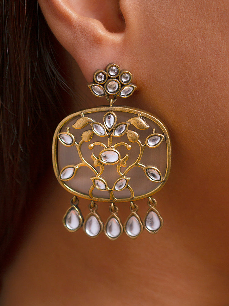 Close-up of a woman wearing an ornate traditional Grey Kundan jewellery set and earrings with Kundan and Colored Stones. Saree look completed with a traditional artificial Kundan set. Woman wearing trending Kundan artificial jewelry for wedding season in India.