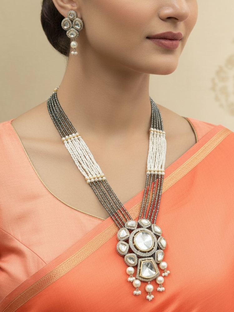 Close-up of a woman wearing an ornate traditional Grey Long jewellery set and earrings with Kundan, American Diamond, pearls and Crystal Beads. Mehendi ceremony look completed with a handcrafted Kundan jewelry set. Wedding guest wearing a lightweight Kundan necklace for a Wedding function.