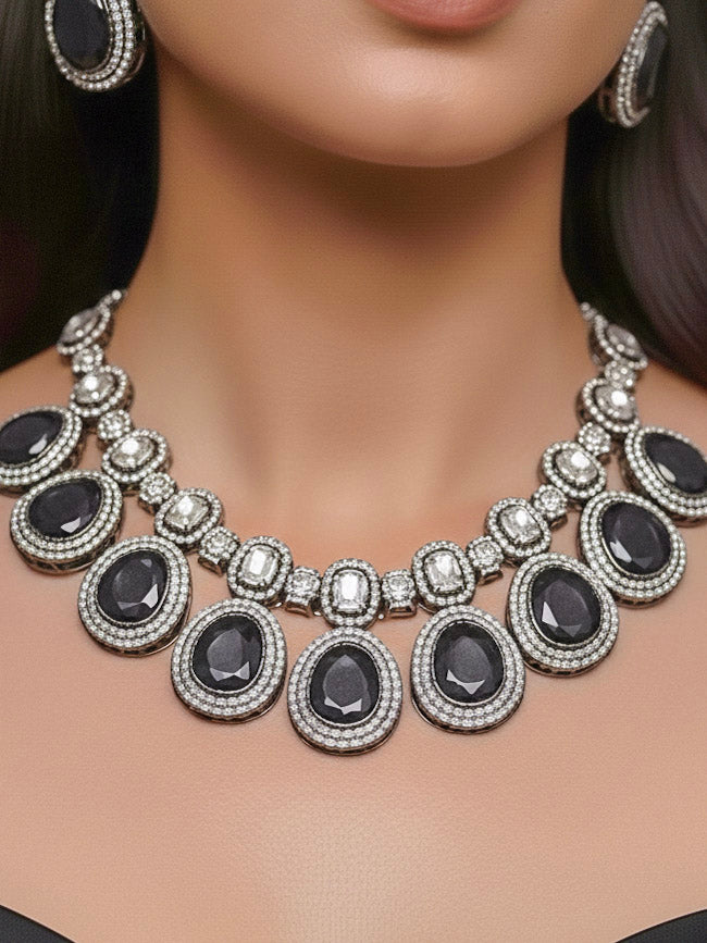 Close-up of a woman wearing an ornate Indo-western American Diamond Grey Collar jewellery set and earrings with American Diamonds and Monalisa Stones. Woman styling a statement American diamond necklace with an off-shoulder gown for a reception. Close-up of a luxury American Diamond imitation necklace styled.