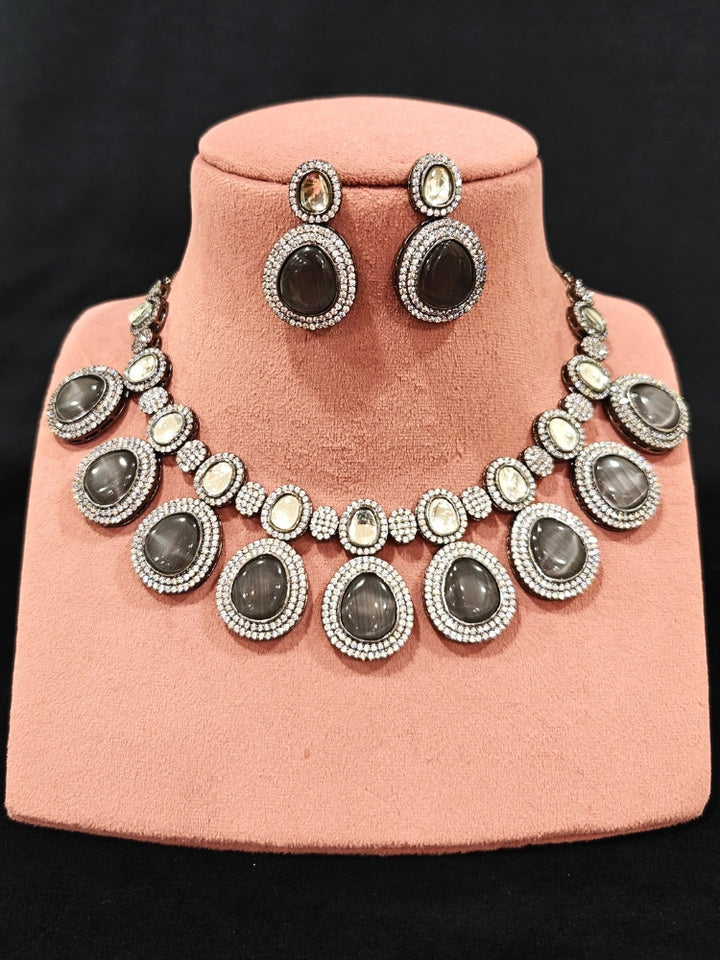 Close-up of an ornate Indo-western American Diamond Grey Collar jewellery set and earrings with American Diamonds and Monalisa Stones. a statement American diamond necklace with an off-shoulder gown for a reception. Close-up of a luxury American Diamond imitation necklace styled.