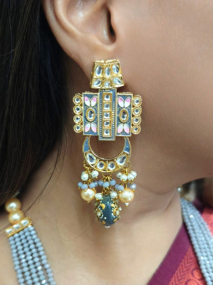 Close-up of a woman wearing an ornate traditional Grey Rajwadi and Meenakari gold Long jewellery set and earrings  with Kundan, Meenakari work, crystal beads and pearls. Woman styled in a royal Rajwadi and Meenakari artificial necklace set for a traditional Indian wedding. Luxury imitation Rajwadi and Meenakari necklace worn for wedding celebrations.