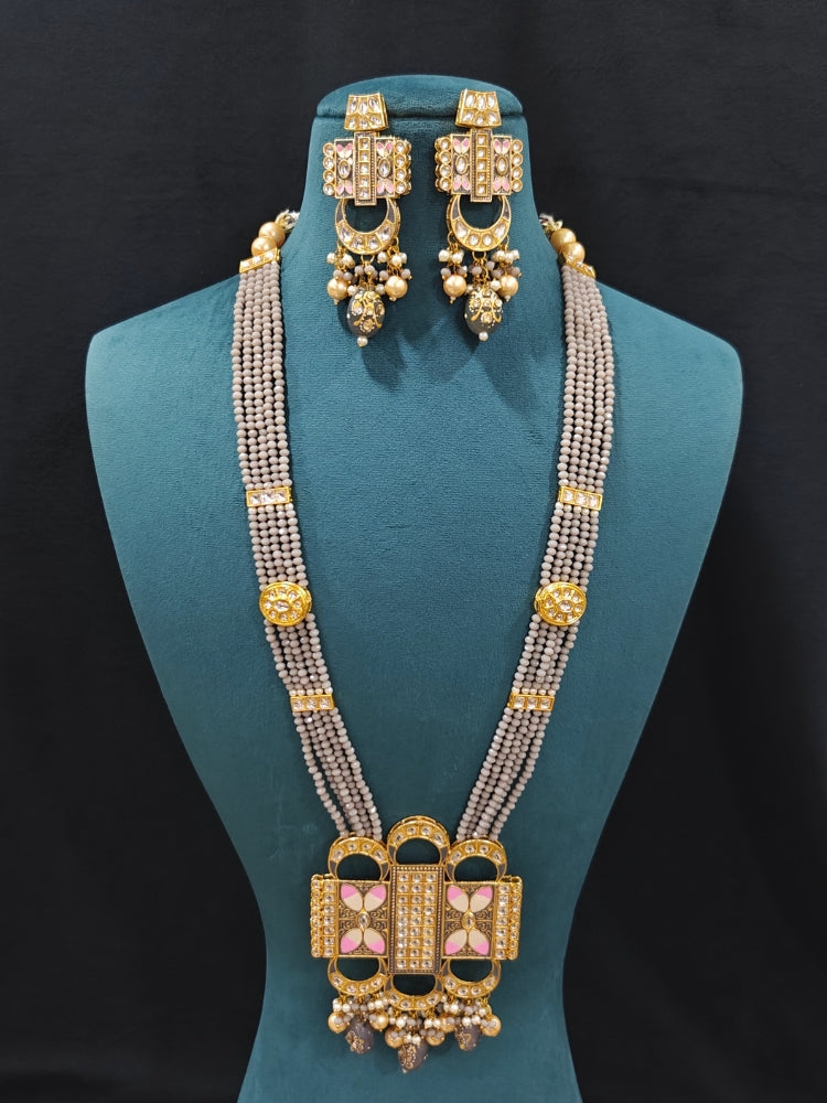 Close-up of an ornate traditional Grey Rajwadi and Meenakari gold Long jewellery set and earrings  with Kundan, Meenakari work, crystal beads and pearls.  A royal Rajwadi and Meenakari artificial necklace set for a traditional Indian wedding. Luxury imitation Rajwadi and Meenakari necklace worn for wedding celebrations.