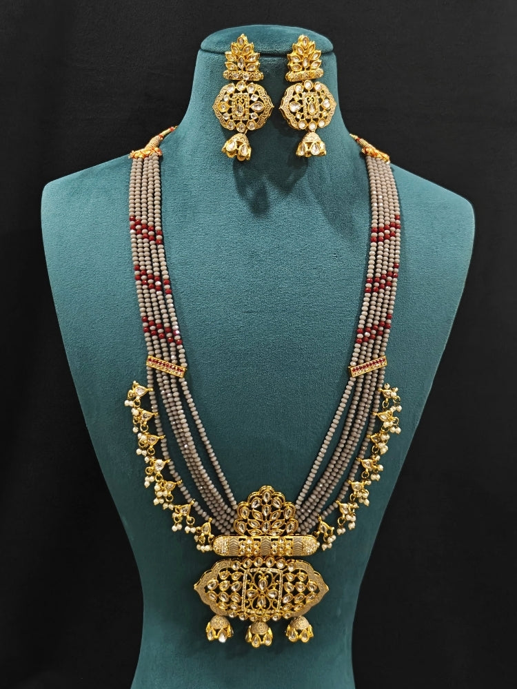 Close-up of an ornate traditional Grey Meenakari gold Long jewellery set and earrings with Kundan, Meenakari work, crystal beads, pearls and American Diamonds. Wedding function styling with a premium Meenakari imitation necklace. Perfect Meenakari necklace set for weddings and festivals.