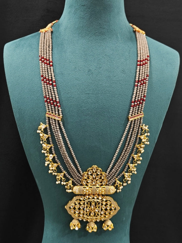 Close-up of an ornate traditional Grey Meenakari gold Long jewellery set and earrings with Kundan, Meenakari work, crystal beads, pearls and American Diamonds. Wedding function styling with a premium Meenakari imitation necklace. Perfect Meenakari necklace set for weddings and festivals.