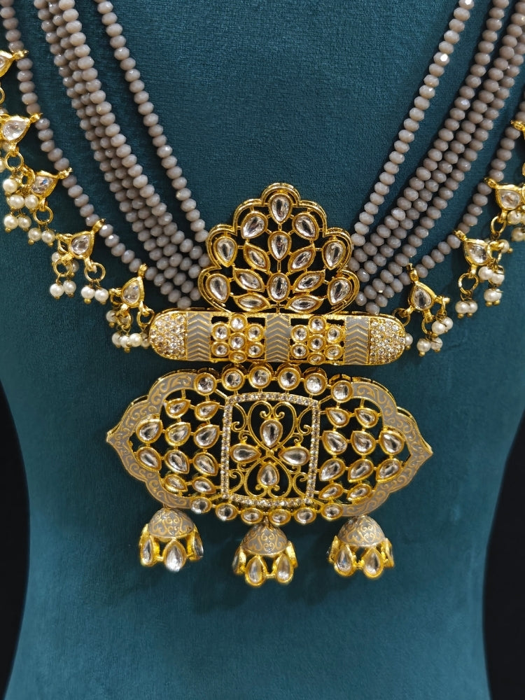 Close-up of an ornate traditional Grey Meenakari gold Long jewellery set and earrings with Kundan, Meenakari work, crystal beads, pearls and American Diamonds. Wedding function styling with a premium Meenakari imitation necklace. Perfect Meenakari necklace set for weddings and festivals.